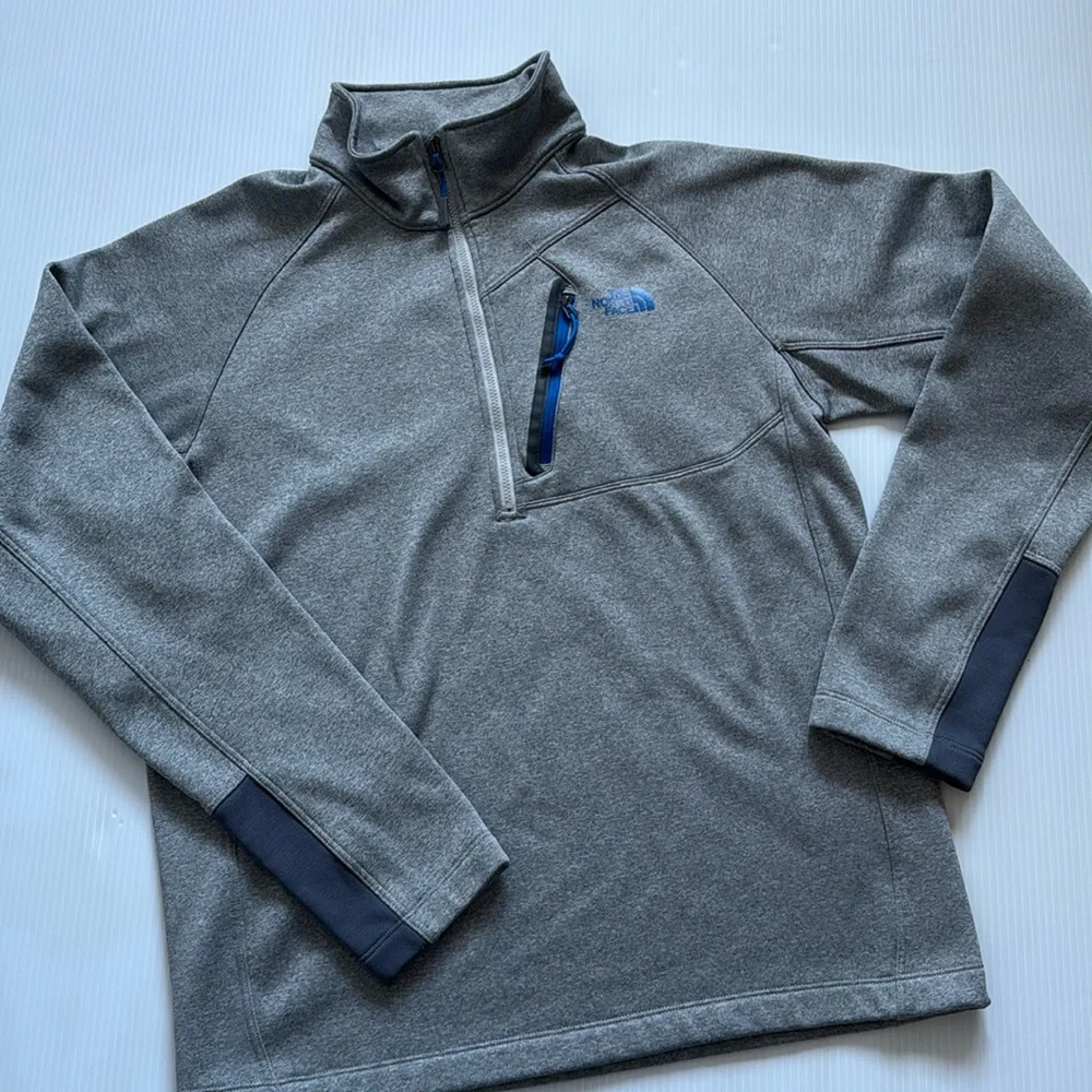 The North Face Men’s gray quarter zip with blue details. Size medium